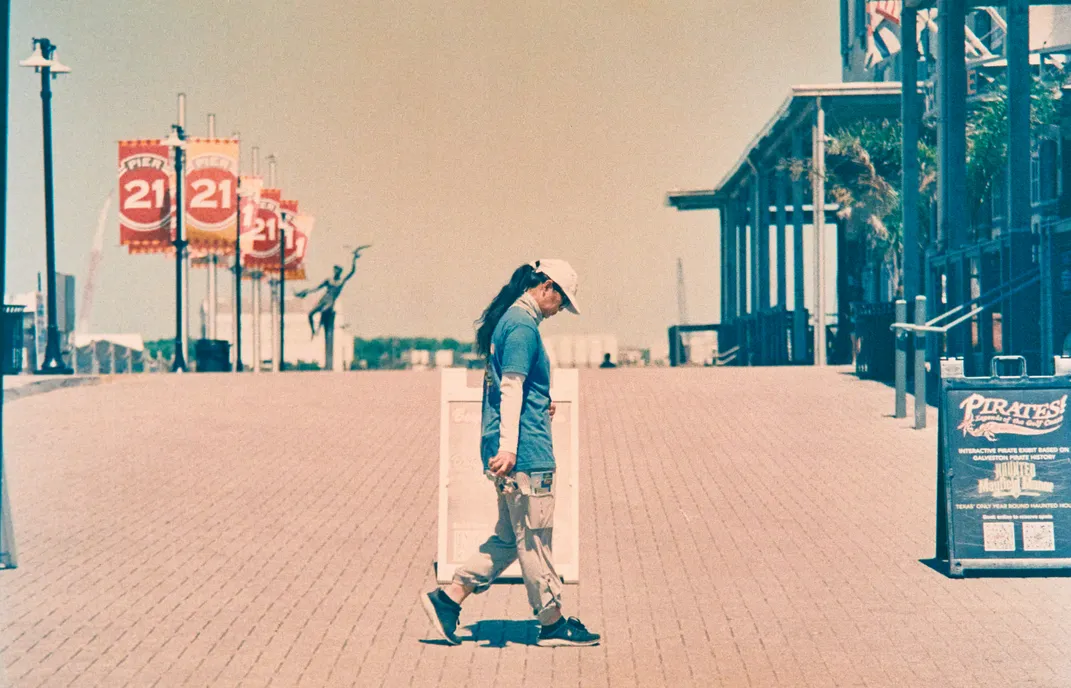 A person walks between buildings on Pier 21