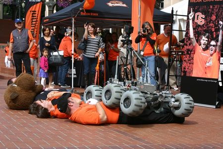 In the grand tradition of college marching band tomfoolery, the Oregon State University Mars Rover cuts a path over marching band members and the OSU mascot.