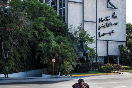 Ernesto Guevara cruises by an image of his father on a building in Havana's Plaza of the Revolution, one of the larges public squares in the world.