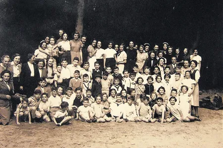 Child refugees from Germany and Austria at the Amsterdam Burgerweeshuis orphanage. Truus Wijsmuller stands at far left, looking at the children she helped save.