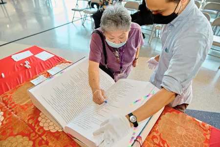 Japanese American National Museum volunteer Barbara Keimi stamps the Ireichō.