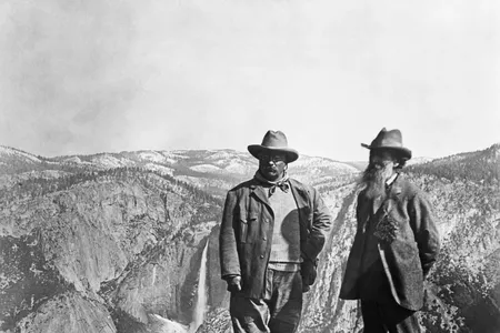 Theodore Roosevelt stands with naturalist John Muir on Glacier Point, above Yosemite Valley, California, USA.