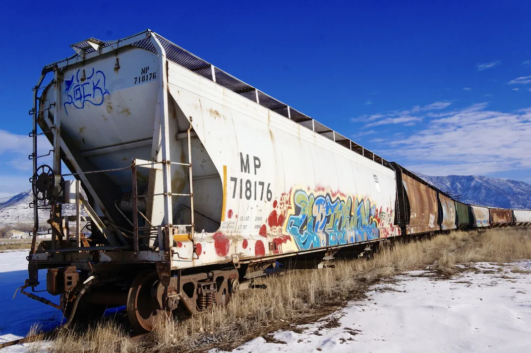 OPENER - Tagged with graffiti, this train car is one of many rusted, old locomotives dotting this mountainous west landscape, where a processing center once stood.