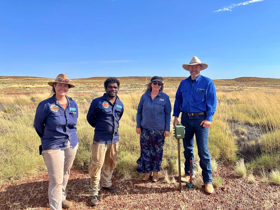 four people standing in the Australian outback