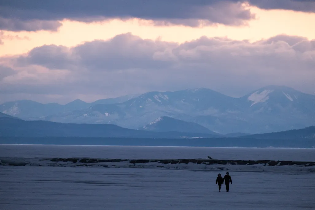 Two people walking on lake champlain