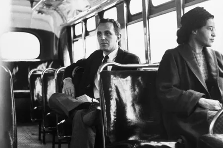 For a photo op, Rosa Parks sits in the front of a bus on December 21, 1956, the day that Montgomery's buses were officially integrated.