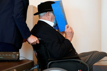 Bruno Dey, a former SS watchman at the Stutthof concentration camp, hides his face behind a folder as he arrives for a hearing in his trial on July 23.