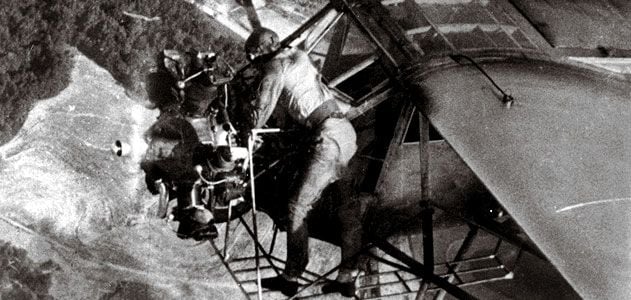 In a 1935 publicity stunt, Fred Key checks the oil in flight.
