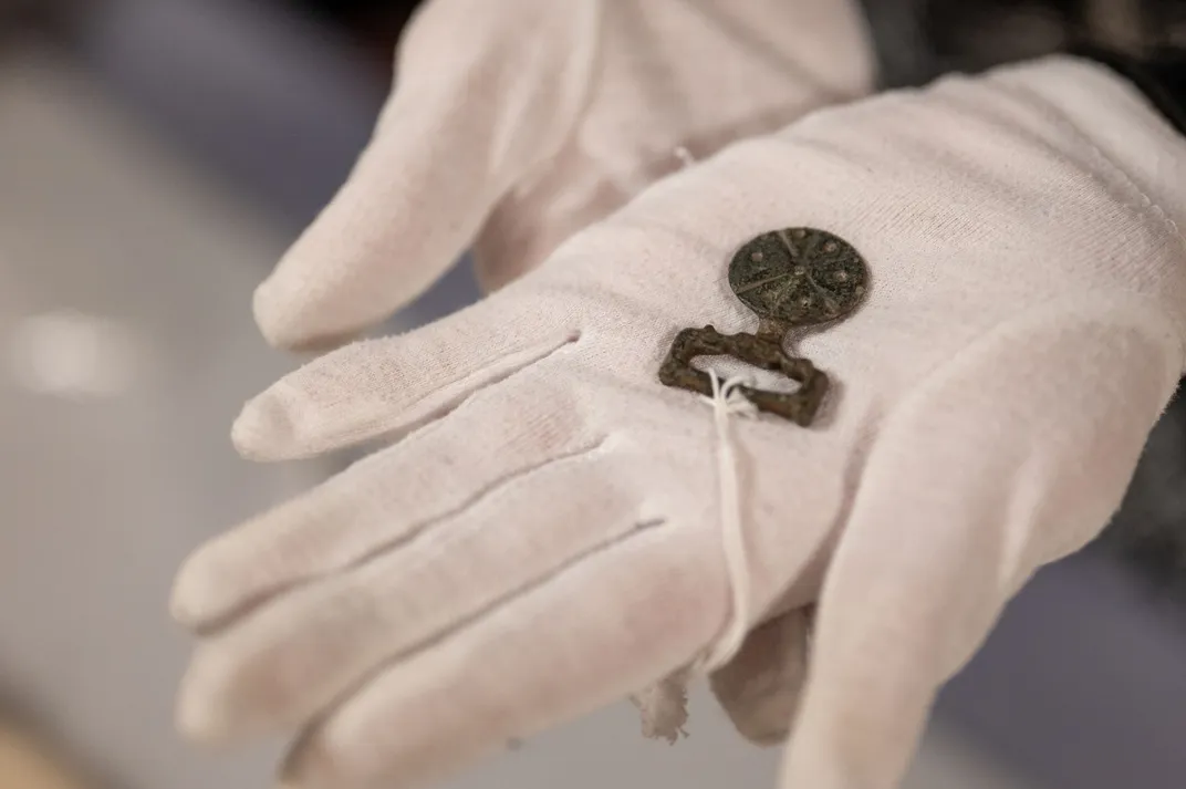 Gloved hands holding a small object