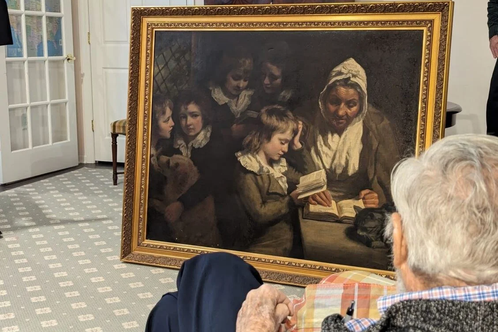 Large painting in a frame in front of a man with white hair
