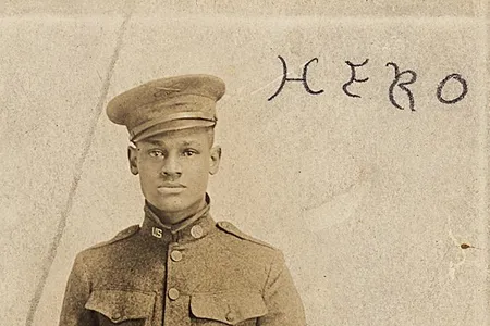 Cpl. Lawrence McVey poses at attention in a photographic postcard. The word "Hero" is inscribed at the top.
