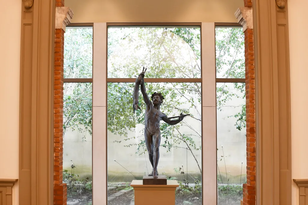 A sculpture of a man framed in a doorway at a museum