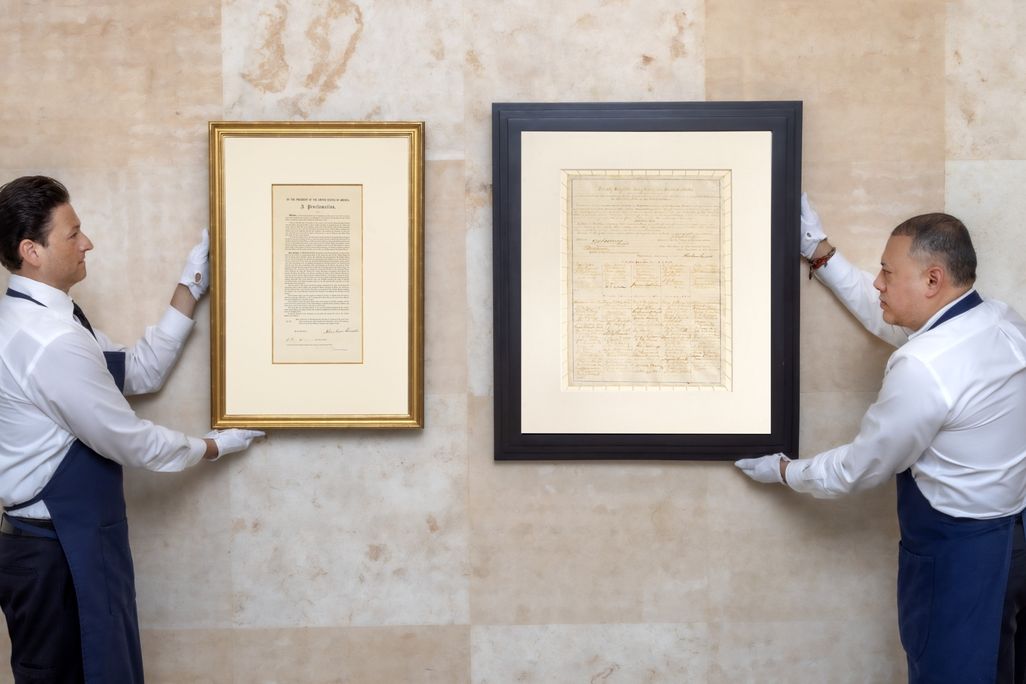Two men holding up framed documents
