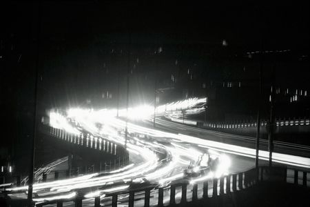 Ribbons of light slash through the darkness that is New York City during the Giant power Failure November (th. The "ribbons" are formed by the lights of vehicles moving along a highway.