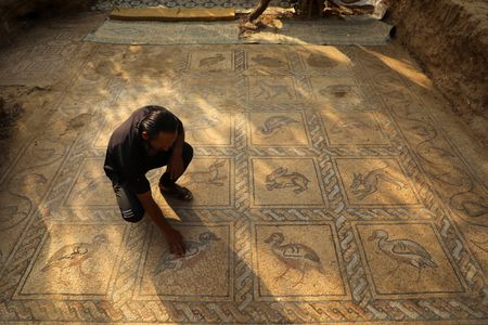 Palestinian farmer Salman al-Nabahin cleans the&nbsp;mosaic&nbsp;he uncovered in Gaza.