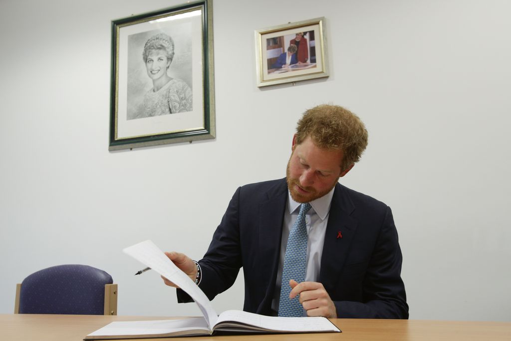 Prince Harry signs the visitors book during a visit to Mildmay hospital, a dedicated HIV hospital.