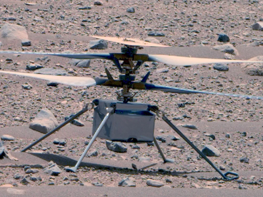 Ingenuity helicopter with its rotor blades out on the rocky Martian surface