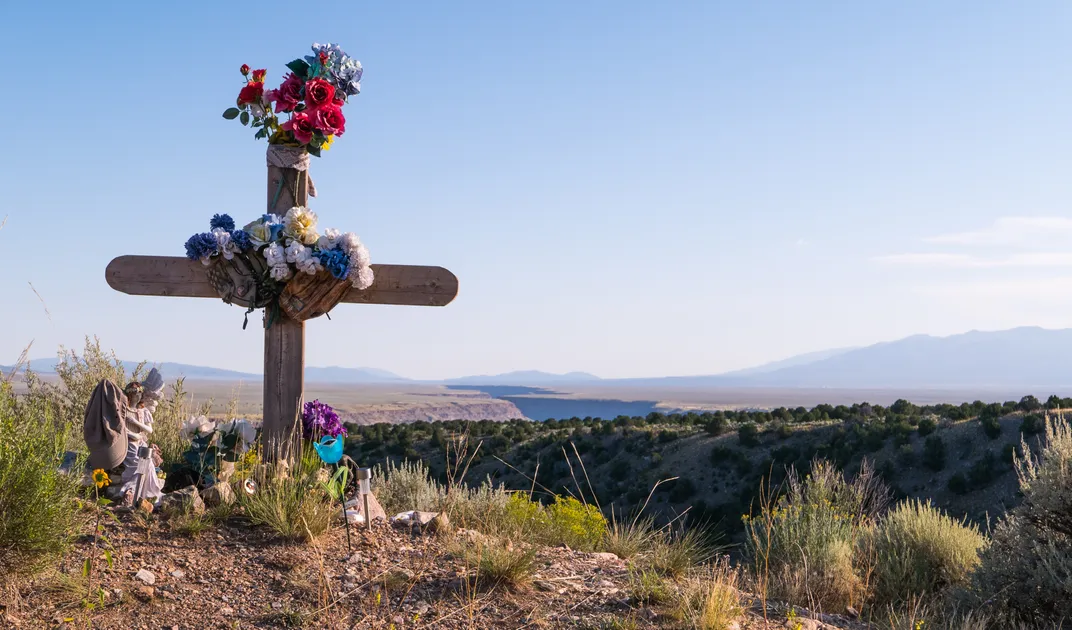 a cross sits in the desert in memoriam