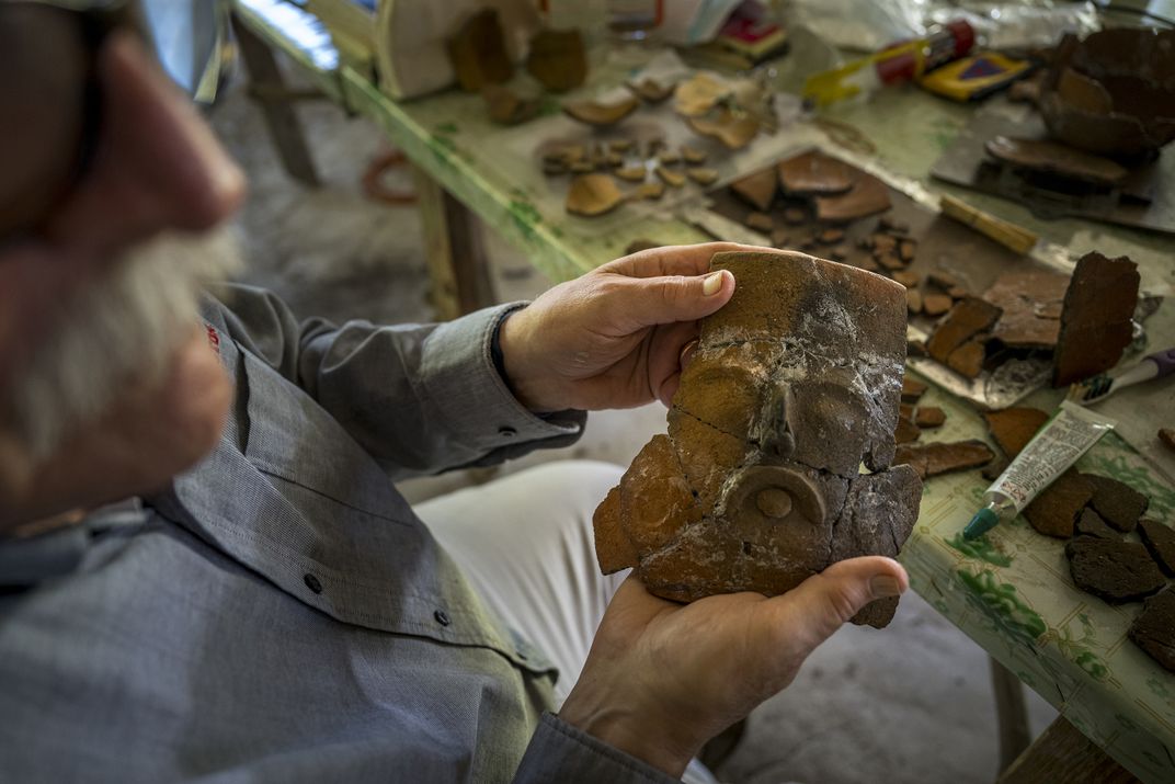 Arlen pieces together a ceramic urn found in a residential area west of Caana.