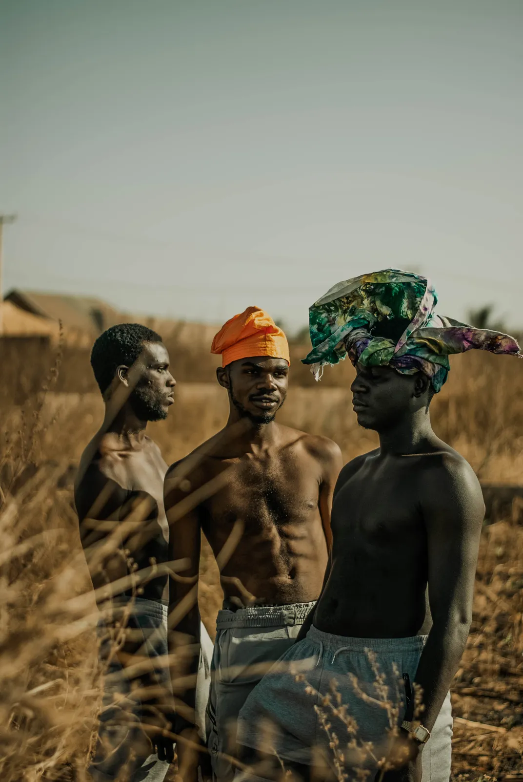 3 African men pose in a field