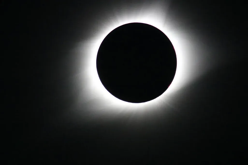 Totality during a total solar eclipse, with the moon fully covering the sun and the corona visible