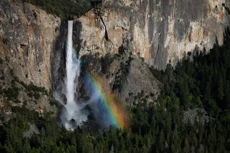The spray from the cascade of Bridalveil Falls captures sunlight to create a rainbow of colors.