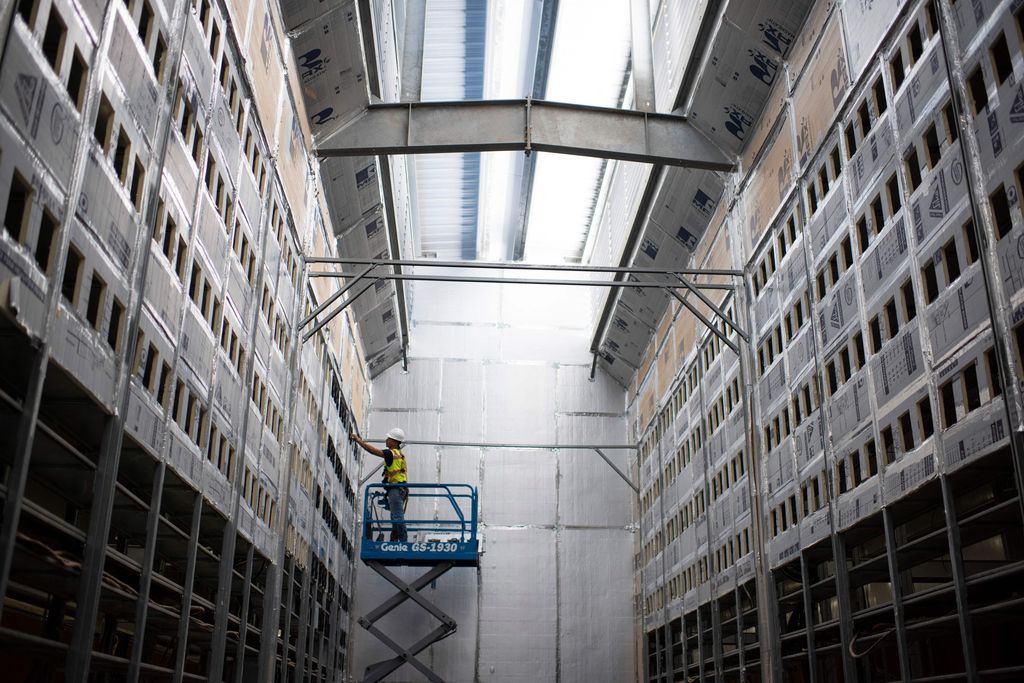 A worker on a lift in a bitcoin mining facility