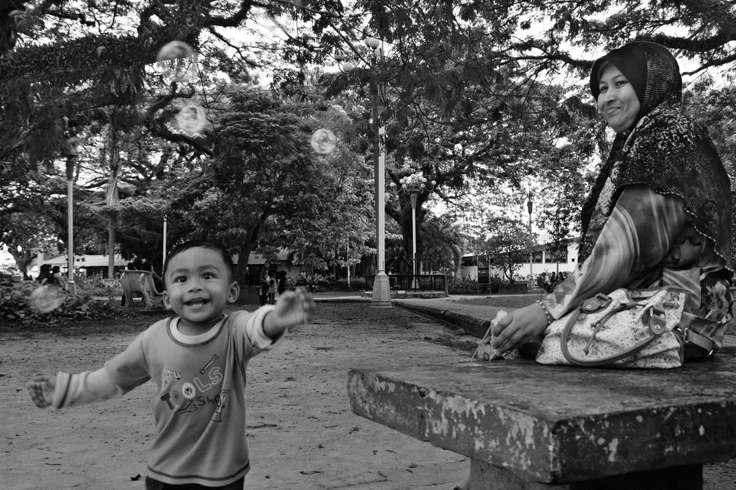 Happy boy chasing bubble | Smithsonian Photo Contest | Smithsonian Magazine