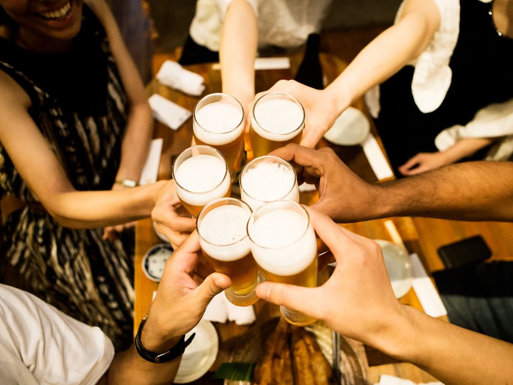 A group of friend cheer full beer glasses together