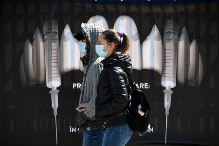 Bran Castle is relying on its connections to the puncture-happy vampire Dracula to entice people to get vaccinated. Here, masked visitors stand in front of a sign depicting syringes as vampire fangs.