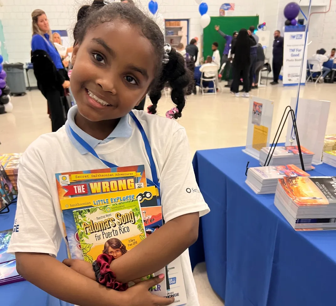 Young girl smiles holding books