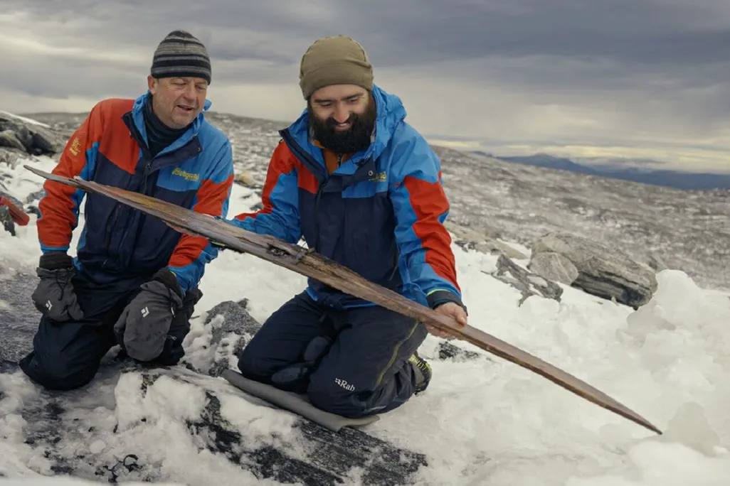 Archaeologists examine the second ski after it was freed from the ice