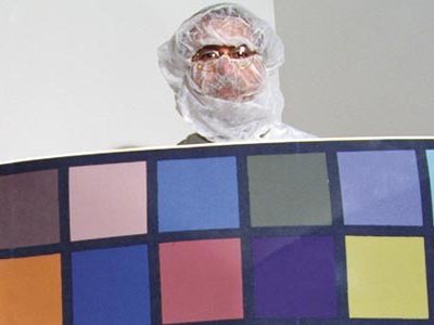 During ground tests in a clean room last July, Mike Malin holds a color chart used to calibrate one of his Mars-bound cameras.
