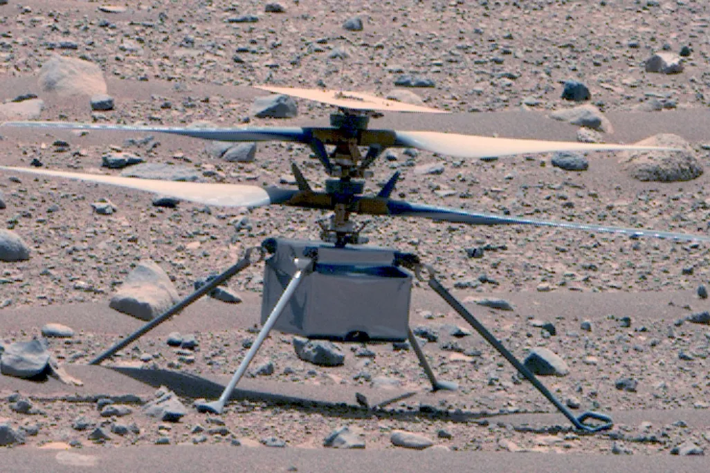 Ingenuity helicopter with its rotor blades out on the rocky Martian surface
