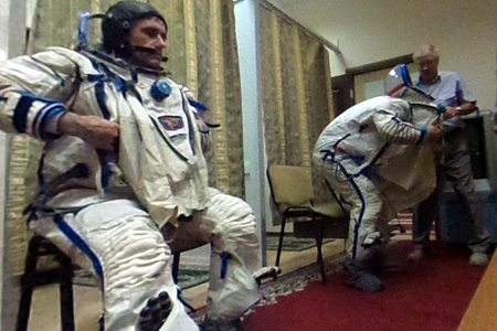 Yuri Malenchenko (left) and Tim Kopra are helped out of their spacesuits after a rehearsal.