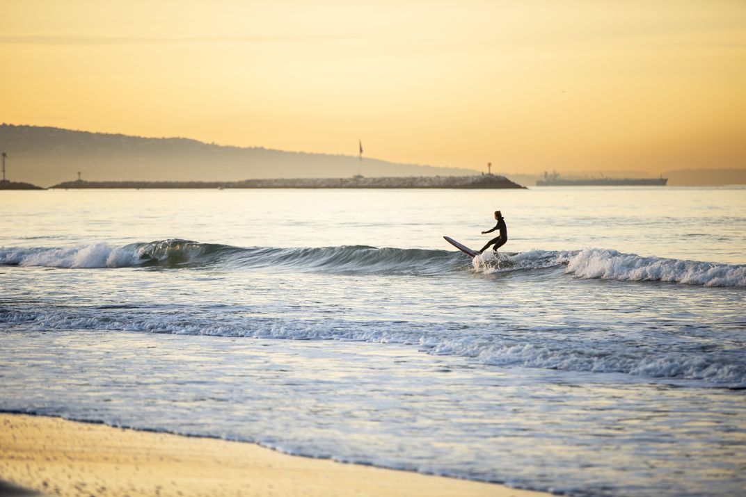 A person surfing at sunset