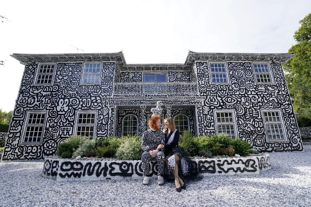 British artist Sam Cox, aka Mr Doodle, with his wife Alena, sitting before the Doodle House.