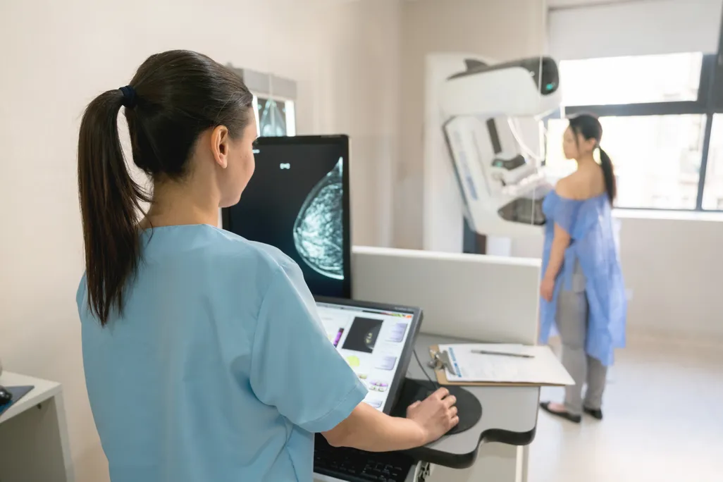 A nurse administering a mammogram