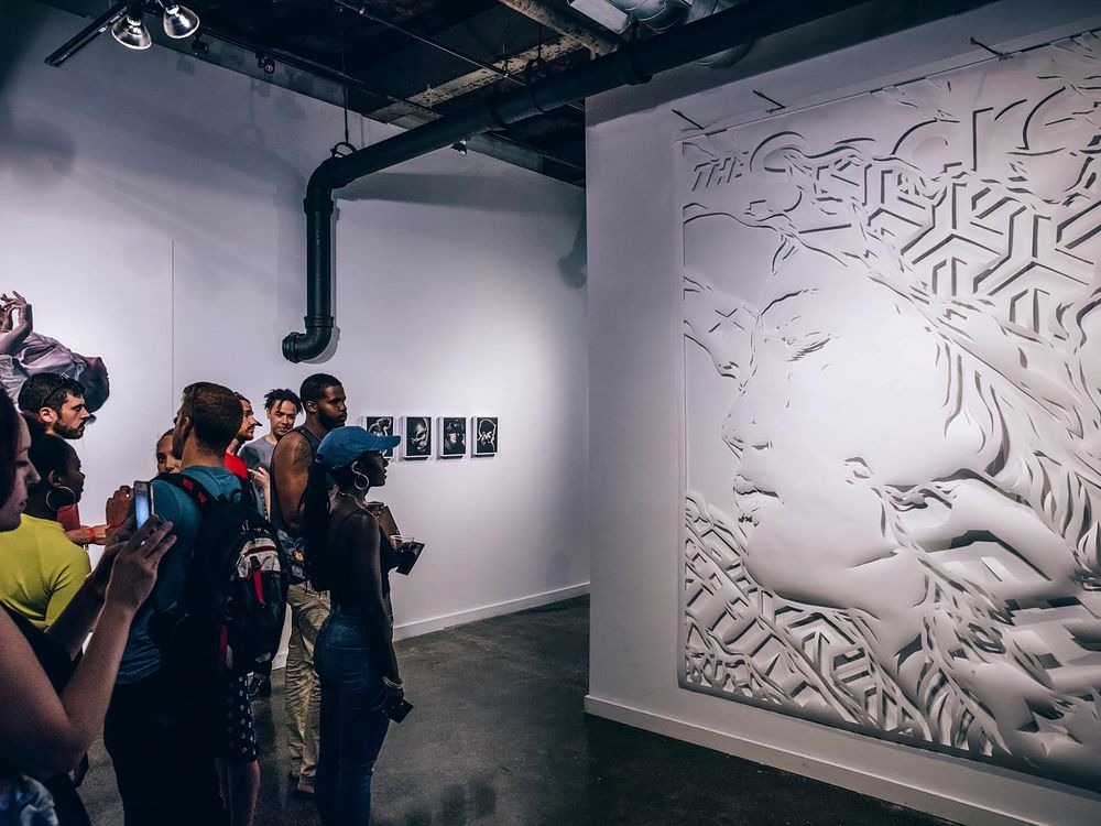 Visitors look at a large, cut-paper work by Ian Kuali’i (Native Hawaiian and Mescalero Apache), on view at the Red Bull House of Art Detroit. Kuali’i was a resident artist at the experimental, noncommercial arts organization in 2016. (Red Bull, courtesy of Ian Kuali’i)
