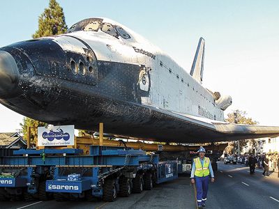 The orbiter Endeavour dwarfs Sarens operator Gordon Lofts – and everyone else along the route – as it negotiates the 12 miles from airport to science center.