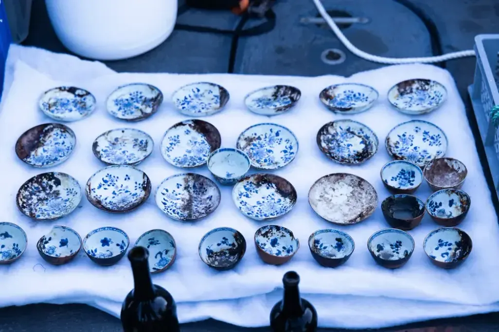 Multiple blue and white ceramic dishes laid out on a white cloth