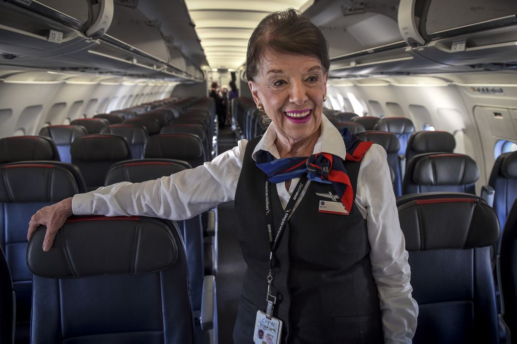 Woman in flight attendant uniform on a plane smiling