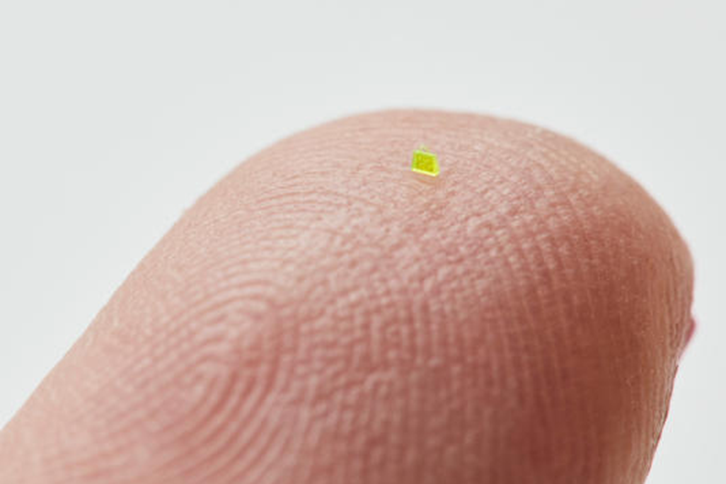 Tiny green handbag on a human fingertip