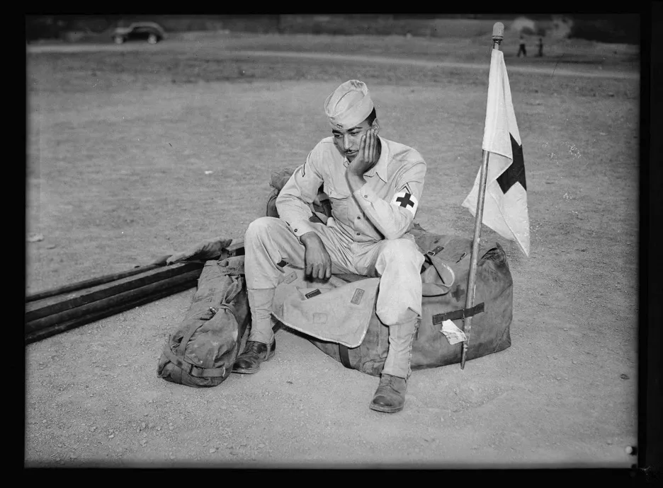 Medic soldier seated on duffel bag