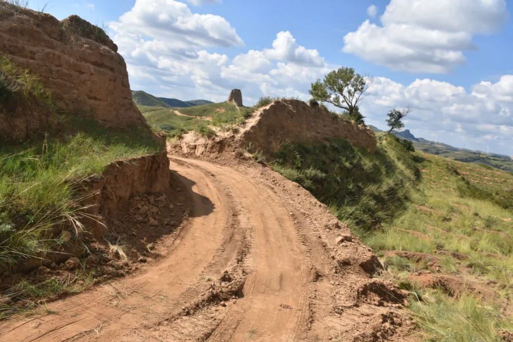 Dirt tire tracks running through gap in Great Wall