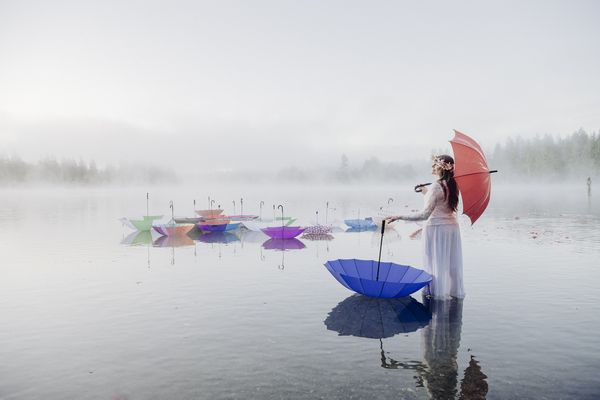 Woman Standing on Lake with Red Umbrella thumbnail