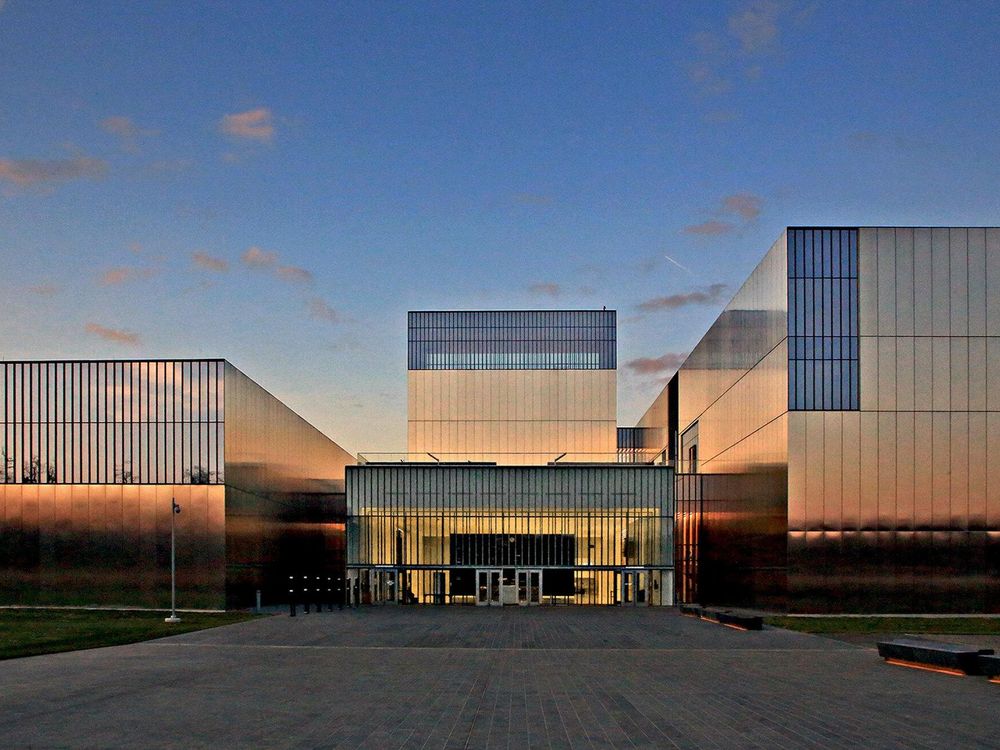 An image of a large, boxy museum with a facade of polished stainless steel and rectangular windows; very modern