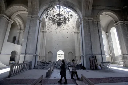Local residents walk through the damaged Ghazanchetsots Cathedral, or Holy Savior Cathedral, in Shushi. Azerbaijani forces targeted the cathedra during a six-week offensive designed to regain control of the region.