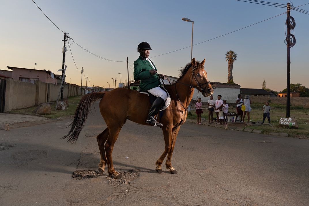 Enos Mafokate proudly wears his South African show jumping jacket on a ride through the streets of Soweto.