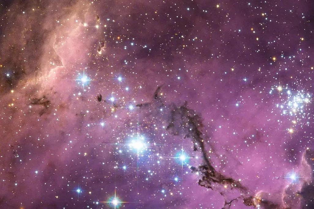 The Large Magellanic Cloud floats in space, in a long and slow dance around our galaxy. Vast clouds of gas within it slowly collapse to form new stars. In turn, these light up the gas clouds in a riot of colors.